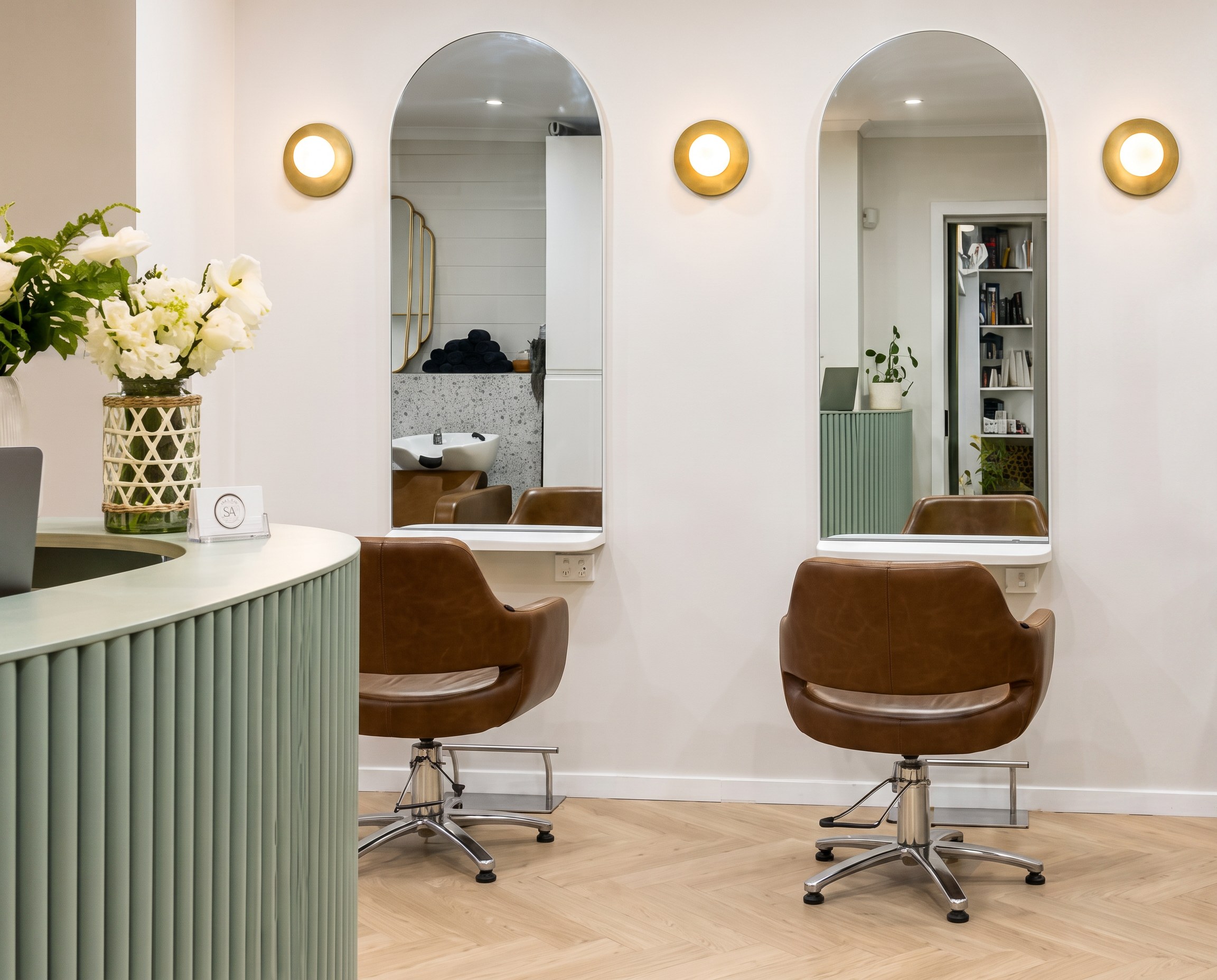 Arched mirrors and tan leather styling chairs