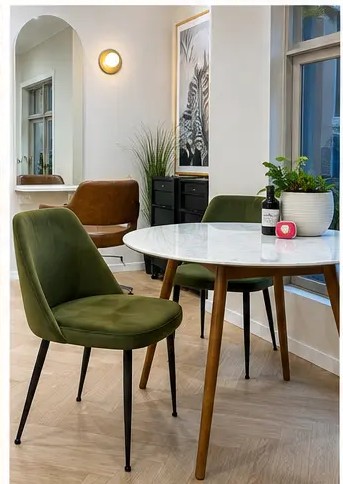 Olive velvet chairs around a marble waiting table