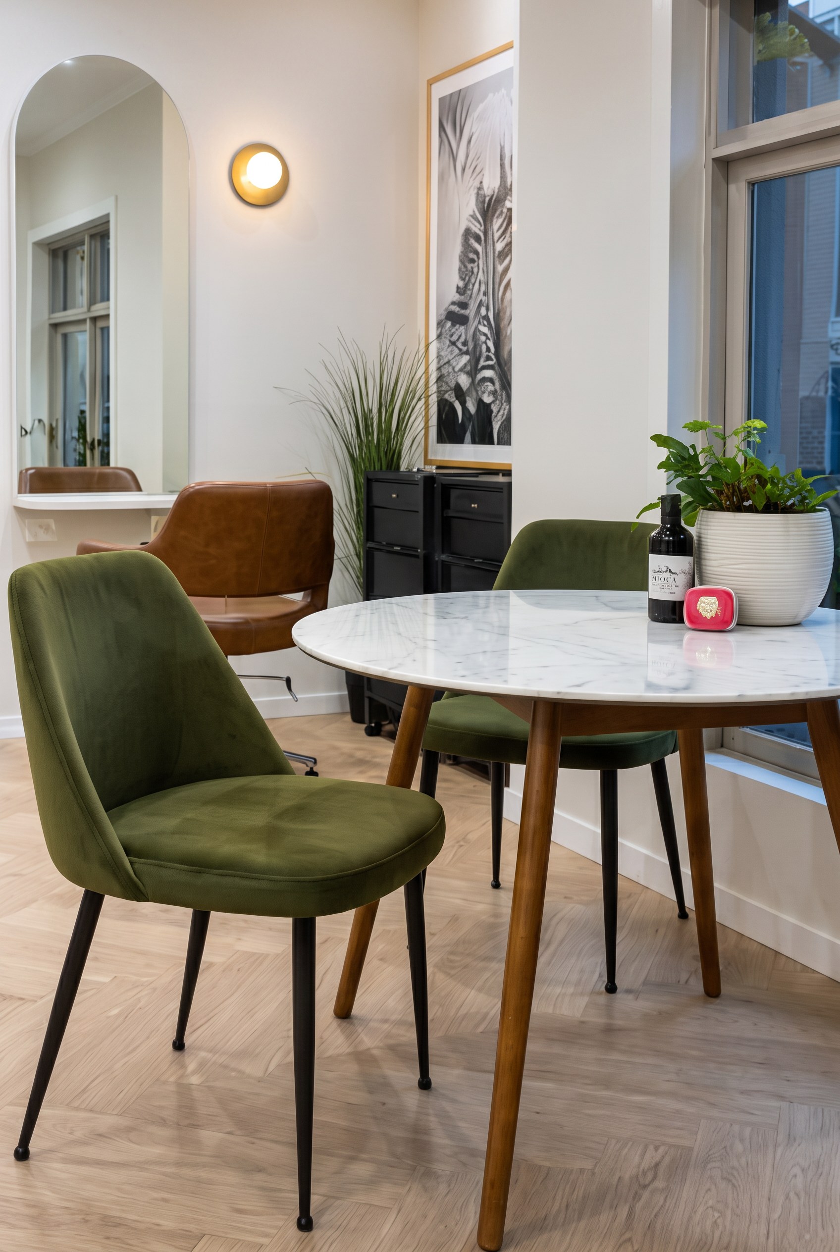 Olive velvet chairs around a marble waiting table