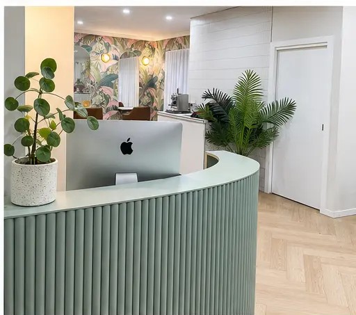 Reception desk with iMac and greenery at Arlo & Co